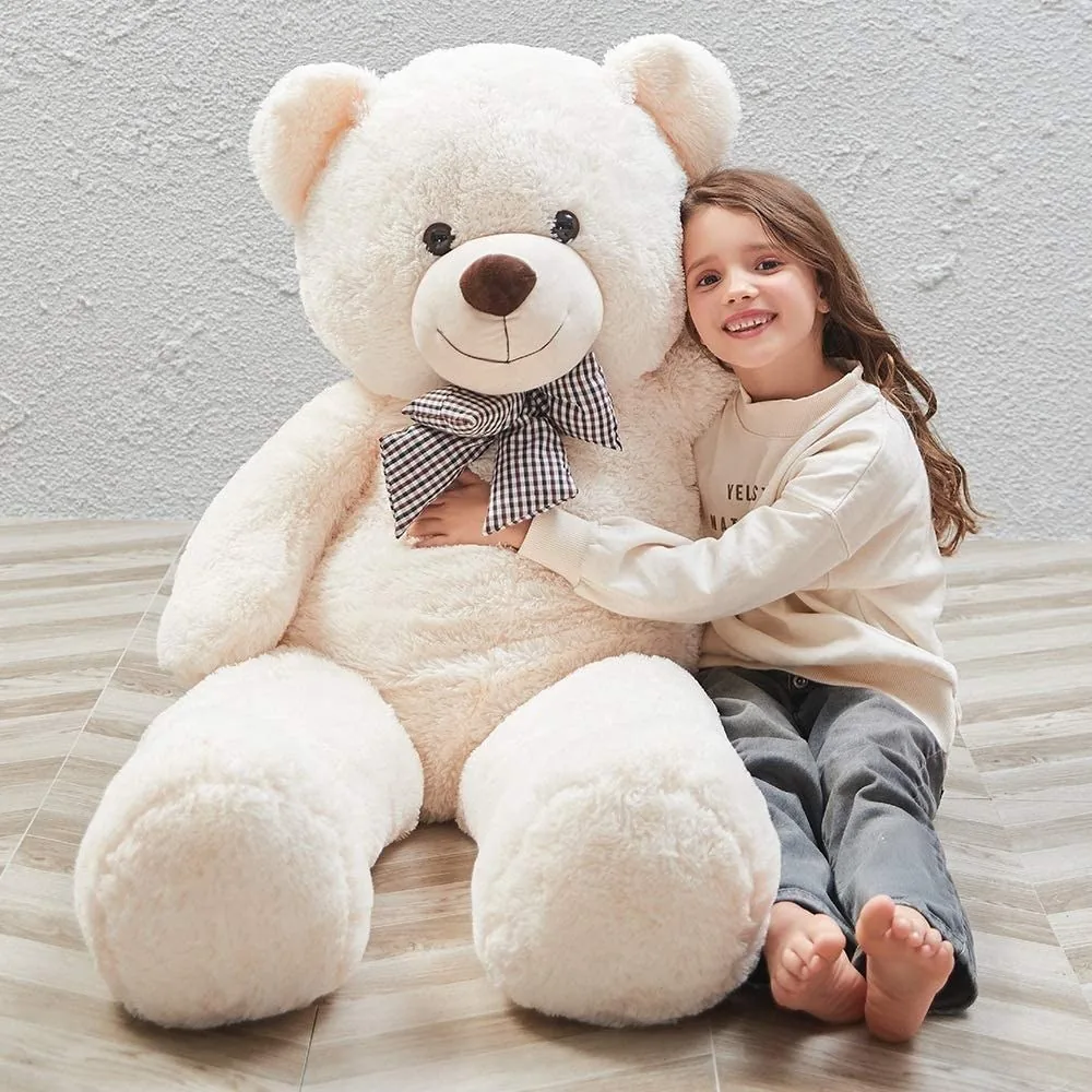 A teddy bear peeking from behind wrapped gifts